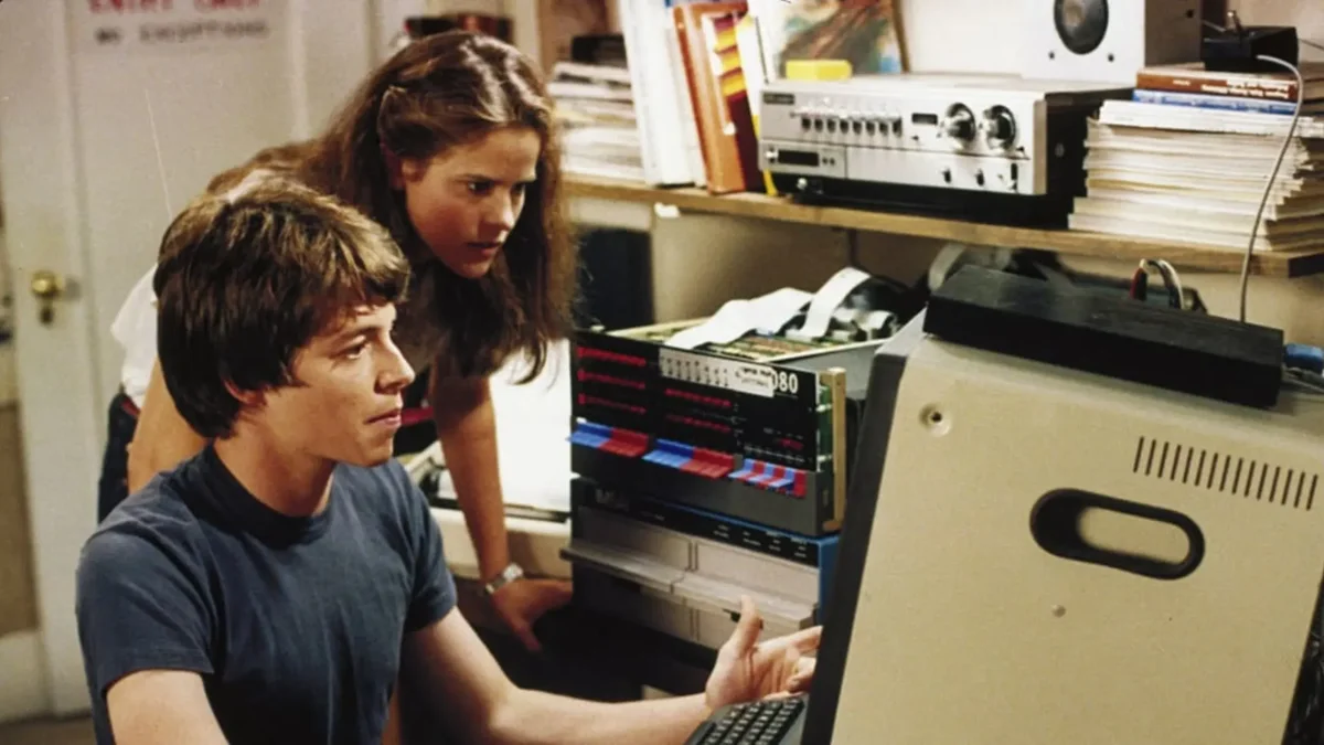 Matthew Broderick y actriz frente a computadora vintage años ochenta escena película